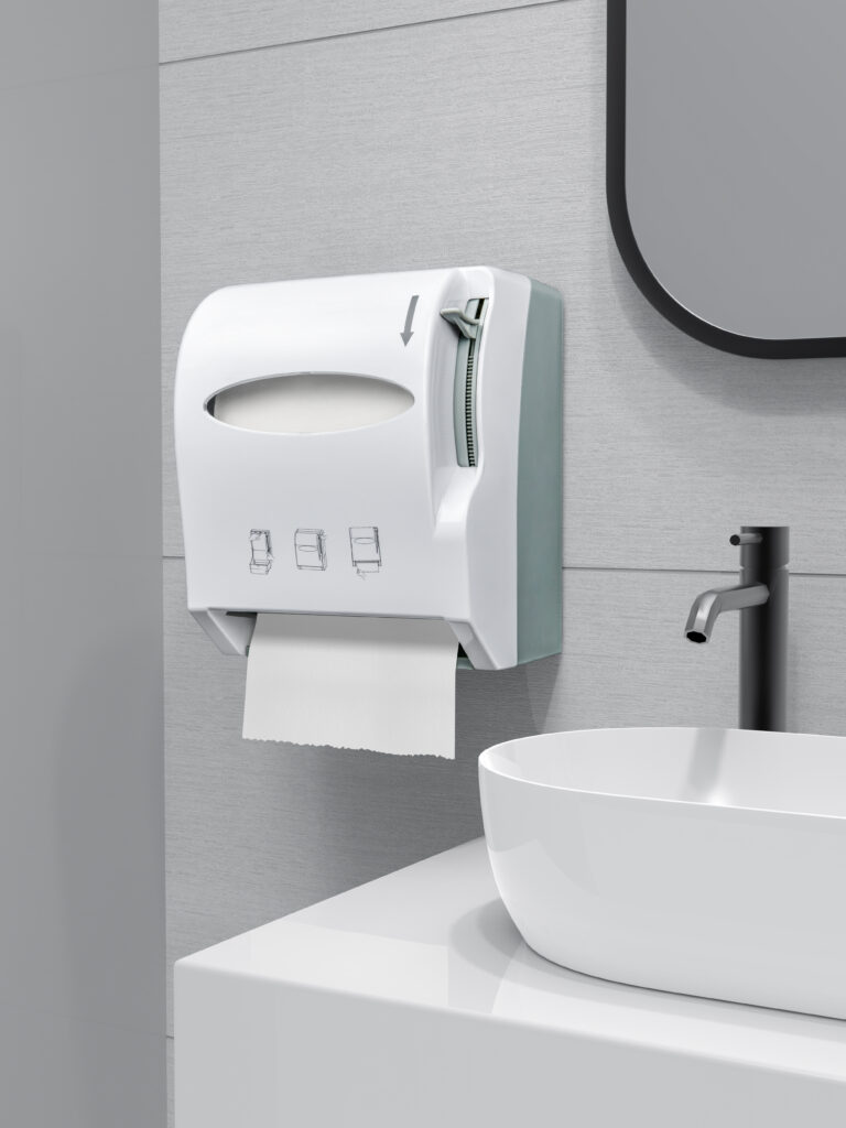 White wall mounted paper towel dispenser with pull mechanism installed above a modern sink in a sleek commercial restroom The dispenser features an intuitive design with a visible paper roll
